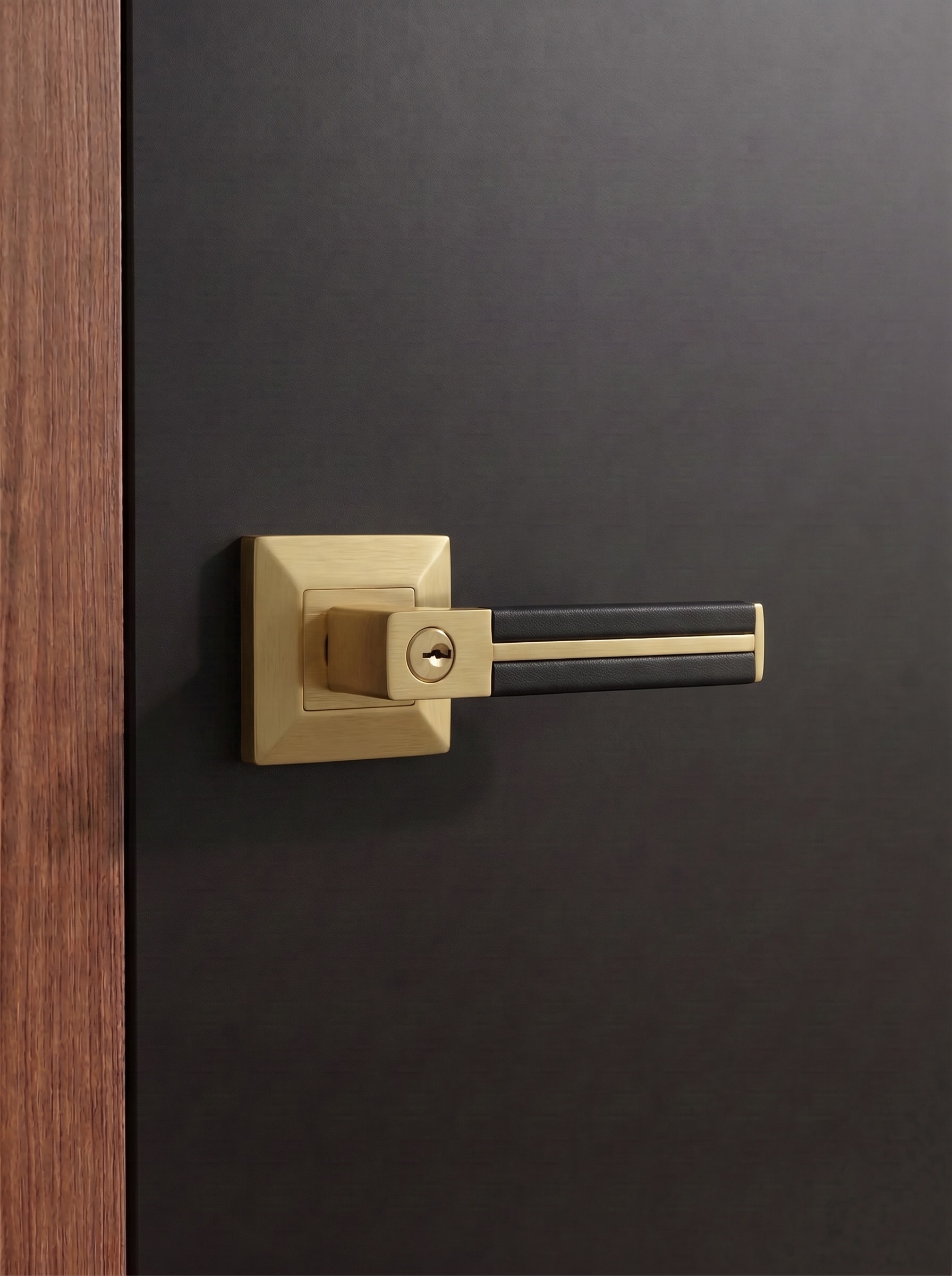 Brass door lever with a hand-finished black leather grip, from the Hamilton Collection